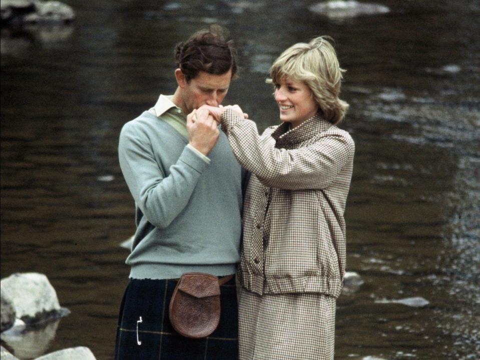 Prince Charles kissing princess Diana's hand on their honeymoon