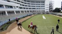 Horses and jockeys make their way in the paddock before a race without spectators amid growing concern about the spread of a new coronavirus, in Funabashi, near Tokyo Saturday, Feb. 29, 2020. (Kyodo News via AP)
