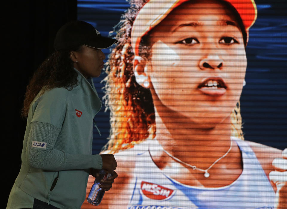 Japan's Naomi Osaka arrives at a press conference after defeating Karolina Pliskova of the Czech Republic in their semifinal at the Australian Open tennis championships in Melbourne, Australia, Thursday, Jan. 24, 2019. (AP Photo/Mark Schiefelbein)