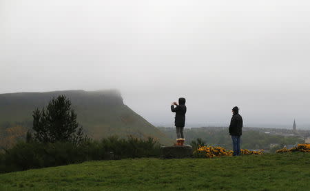 A tourist takes a photograph of Arthur's Seat from Calton Hill in Edinburgh, Scotland April 30, 2014. REUTERS/Suzanne Plunkett