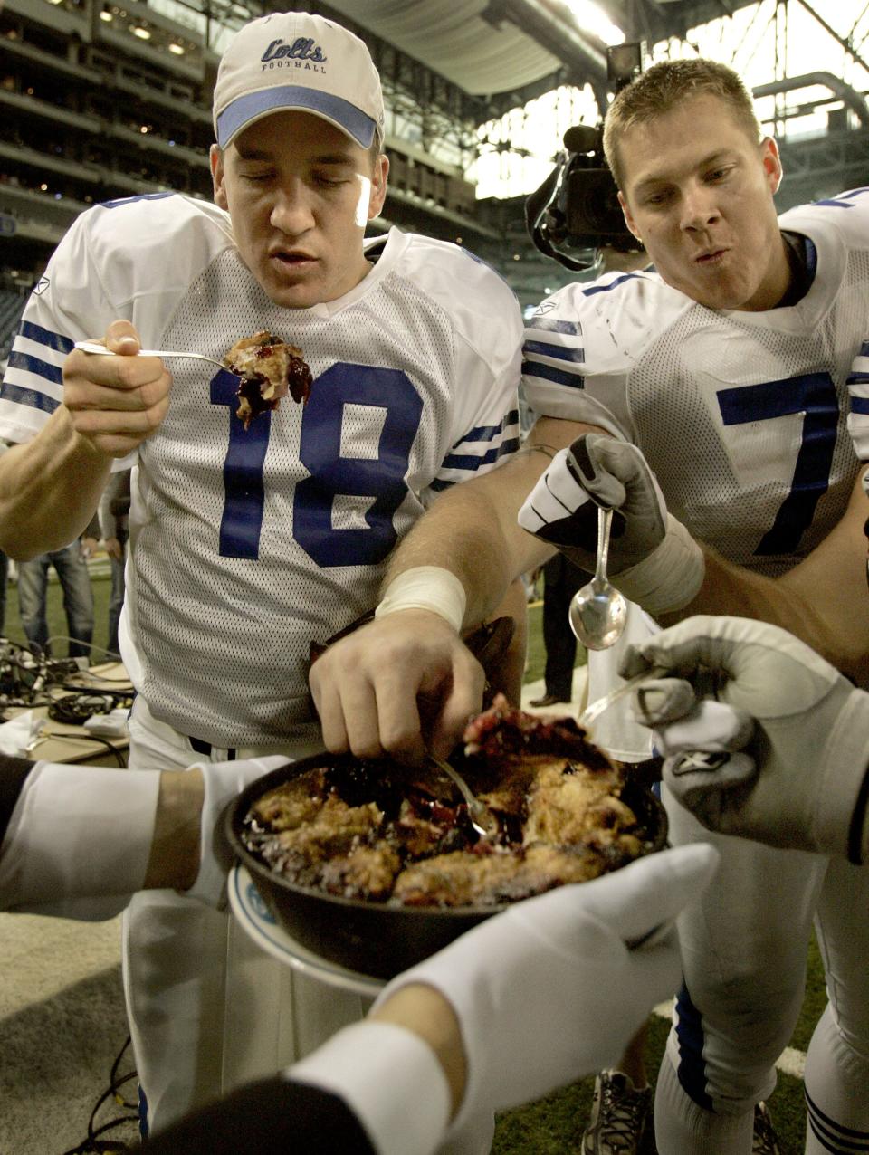 COLTS26 106122 11/25/04 SAM RICHE / THE INDIANAPOLIS STAR:Peyton Manning, and his offensive line, Ryan Diem at right, dig into a Thanksgiving pie after devouring the Lions. The Indianapolis Colts traveled to Detroit, MI to take on the Detroit Lions at Ford Field on Thanksgiving Day, November 25, 2004. The Colts hammered the Lions 41-9.