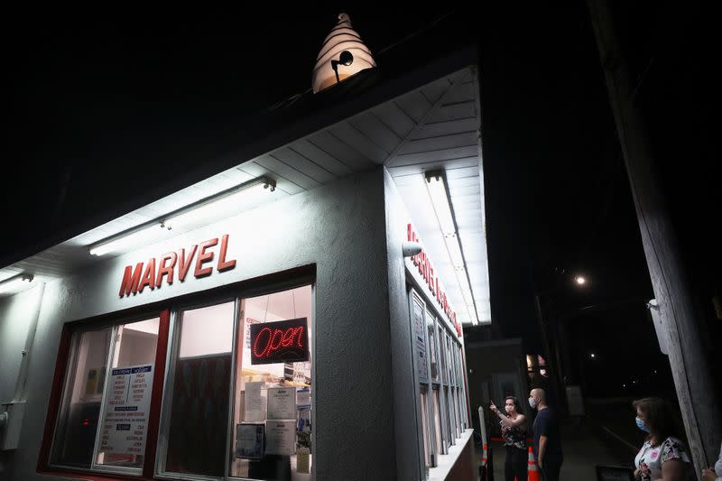 People wearing protective face masks, amid the coronavirus disease (COVID-19) pandemic, order dessert at Marvel Frozen Dairy in Long Beach, New York