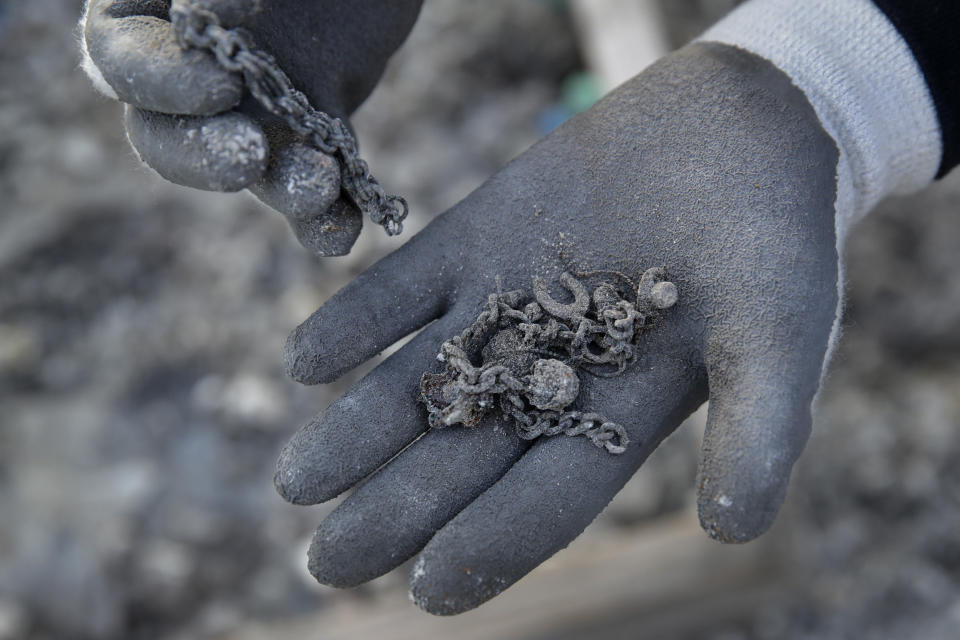 A friend of Bernadette Laos displays jewelry salvaged from her home that was destroyed by the Kincade Fire near Geyserville, Calif., Thursday, Oct. 31, 2019. The fire started last week near the town of Geyserville in Sonoma County north of San Francisco. (AP Photo/Charlie Riedel)