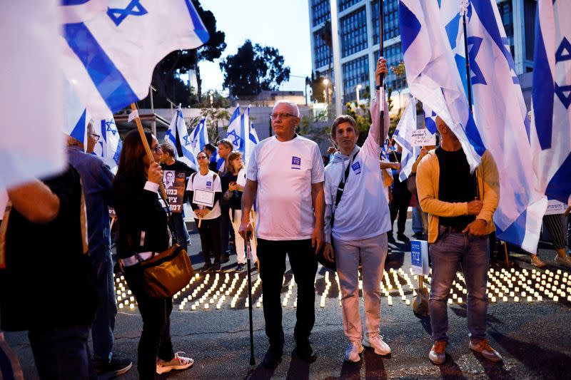 Entrepreneur Uzy Zwebner stands in front of electric candles placed by Israelis who lost their loved ones in Israel's wars, as he attends a protest against Israel's nationalist coalition government's judicial overhaul in Tel Aviv