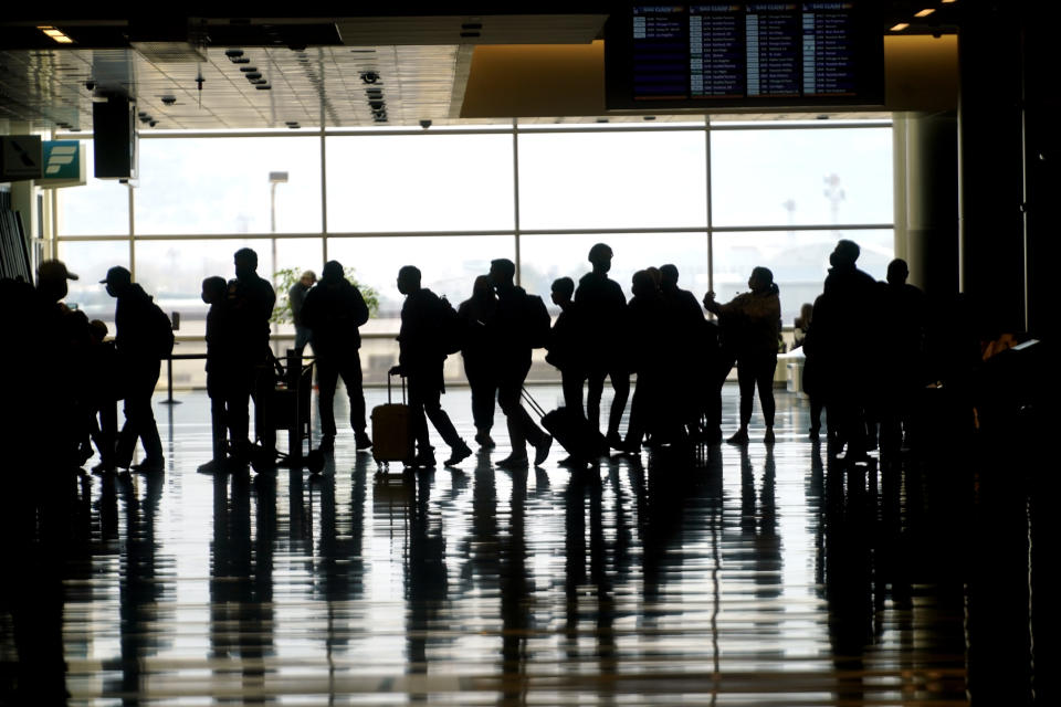 Travelers walk through the Salt Lake City International Airport Wednesday, March 17, 2021, in Salt Lake City. Airlines and others in the travel industry are throwing their support behind vaccine passports to boost pandemic-depressed travel, and authorities in Europe could embrace the idea quickly enough for the peak summer vacation season. (AP Photo/Rick Bowmer)