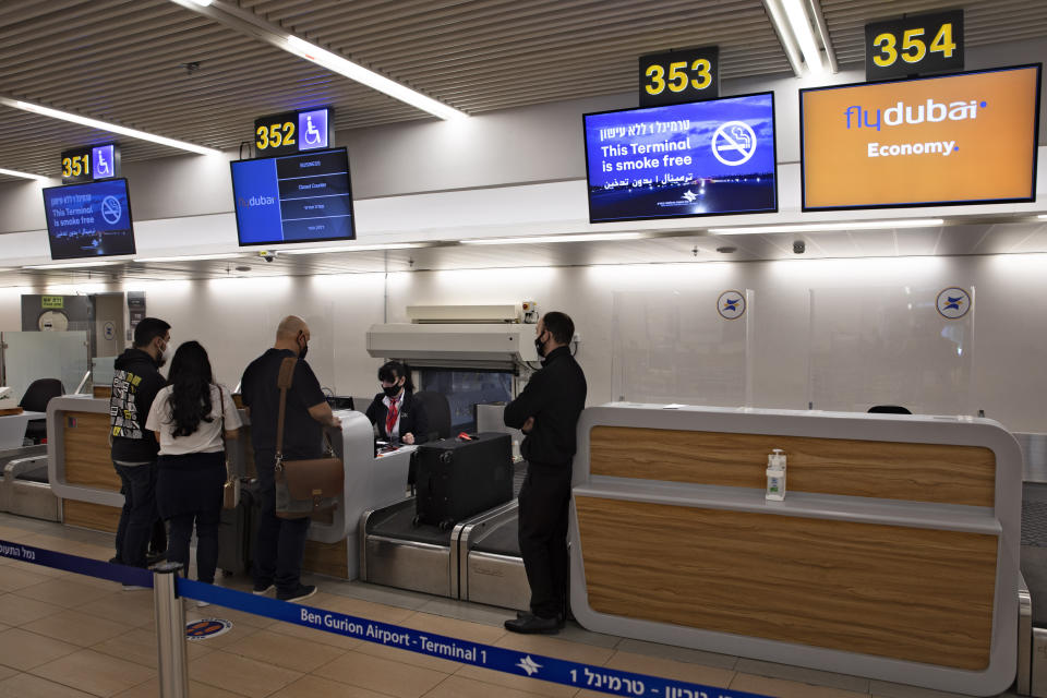 Israelis prepare to fly to Dubai at the Ben Gurion airport near Tel Aviv, Israel, Thursday, Dec. 3, 2020. The Israeli government is urging its citizens to avoid travel to the Gulf states of the United Arab Emirates and Bahrain, citing threats of Iranian attacks. Thursday's travel advisory comes as Iran is threatening to attack Israeli targets following the assassination of its top nuclear scientist last Friday. (AP Photo/Sebastian Scheiner)