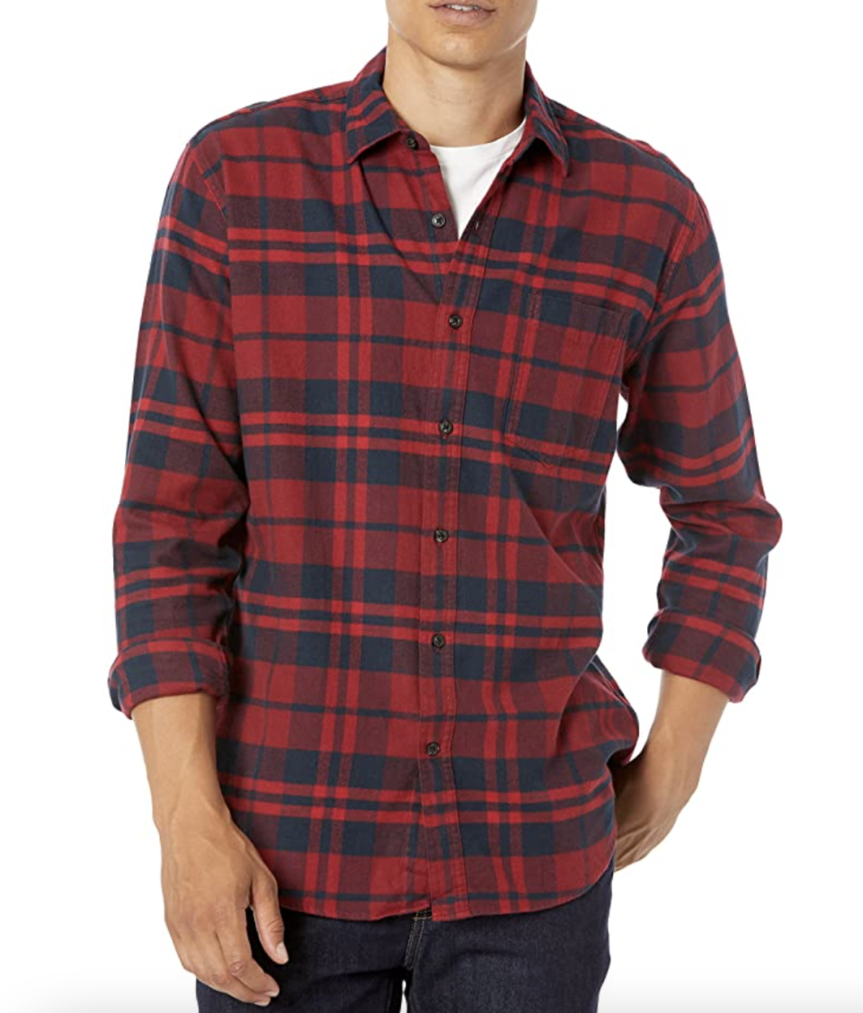 man posing with red and navy blue flannel shirt with hand in pocket