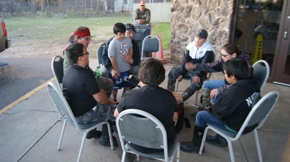 Wayne Valliere (left) joins students in a traditional song.