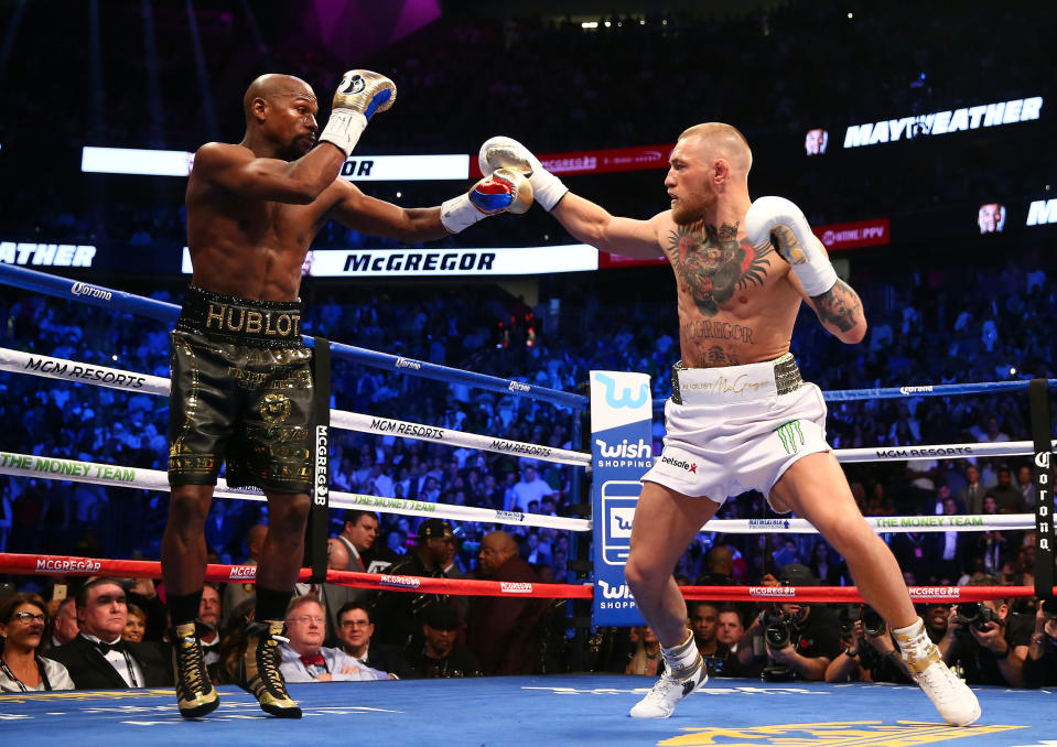 <p>Conor McGregor moves in against Floyd Mayweather Jr. in the first round at T-Mobile Arena. Mandatory Credit: Mark J. Rebilas-USA TODAY Sports </p>