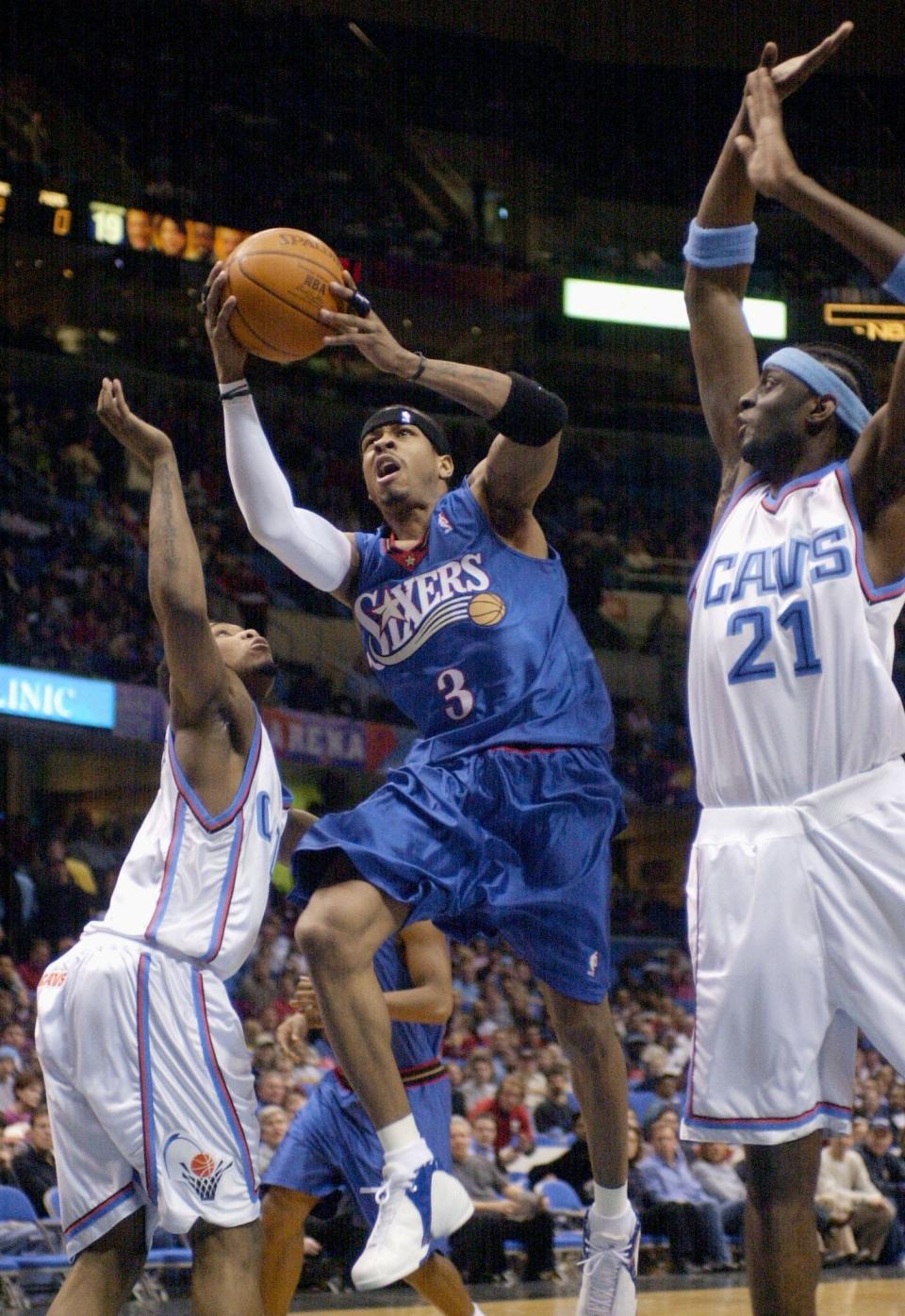 Philadelphia 76ers' Allen Iverson (3) goes up for a shot between Cleveland Cavaliers defenders Dajuan Wagner and Darius Miles (21) during the first quarter Friday, Feb. 21, 2003, in Cleveland.