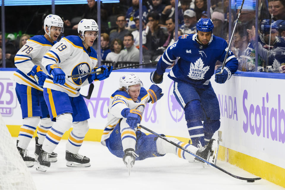 Toronto Maple Leafs right wing Ryan Reaves (75) takes down Buffalo Sabres defenseman Rasmus Dahlin (26) while center Peyton Krebs (19) and defenseman Jacob Bryson (78) watch during the second period of an NHL hockey game Saturday, Nov. 4, 2023, in Toronto. (Christopher Katsarov/The Canadian Press via AP)