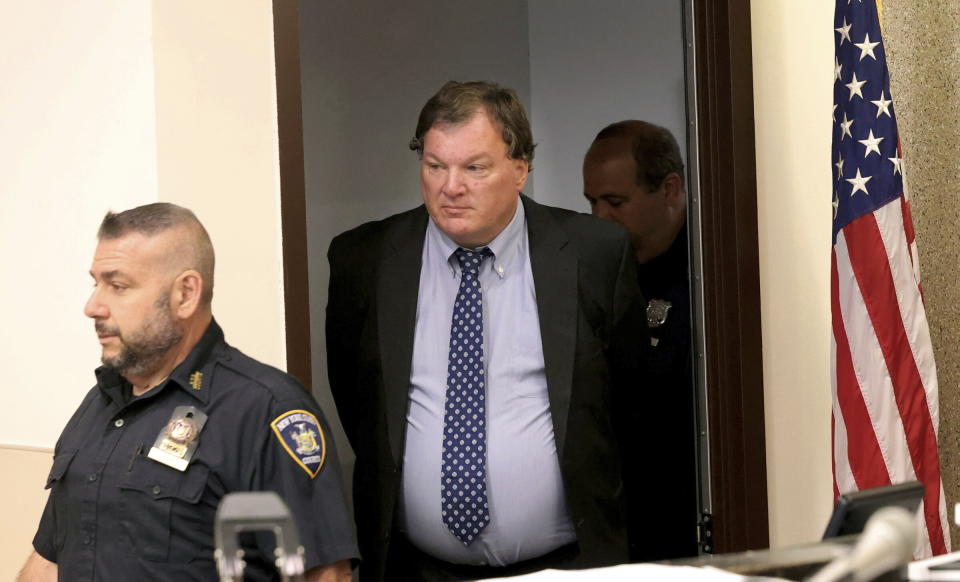 Rex Heuermann, center, charged in the Gilgo Beach serial killings on Long Island, enters the courtroom in Riverhead, N.Y.