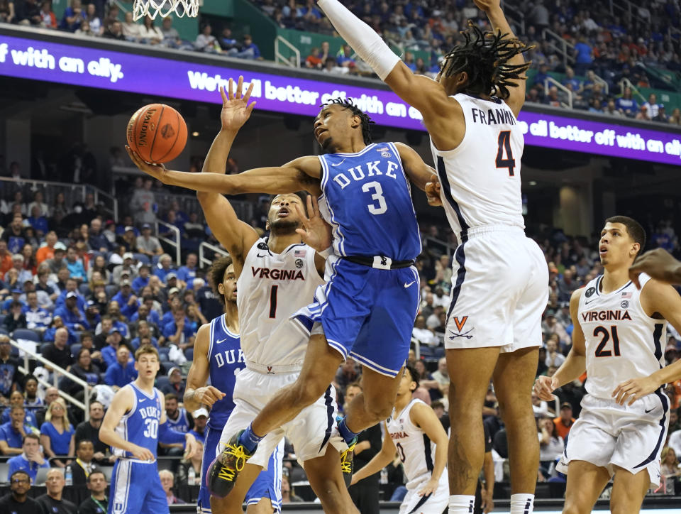 Duke guard Jeremy Roach (3) drives between Virginia forward Jayden Gardner (1) and guard Armaan Franklin (4) during the second half of an NCAA college basketball game for the championship of the Atlantic Coast Conference Tournament in Greensboro, N.C., Saturday, March 11, 2023. (AP Photo/Chuck Burton)