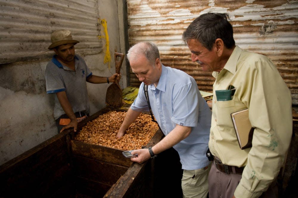 Chocolate-maker Shawn Askinosie, left, and Vitaliano Sarabia (right), president of a cacao farmers cooperative in Ecuador, inspect cacao beans. This photo originally appeared in the Summer 2006 issue of Ozarks Signature magazine.