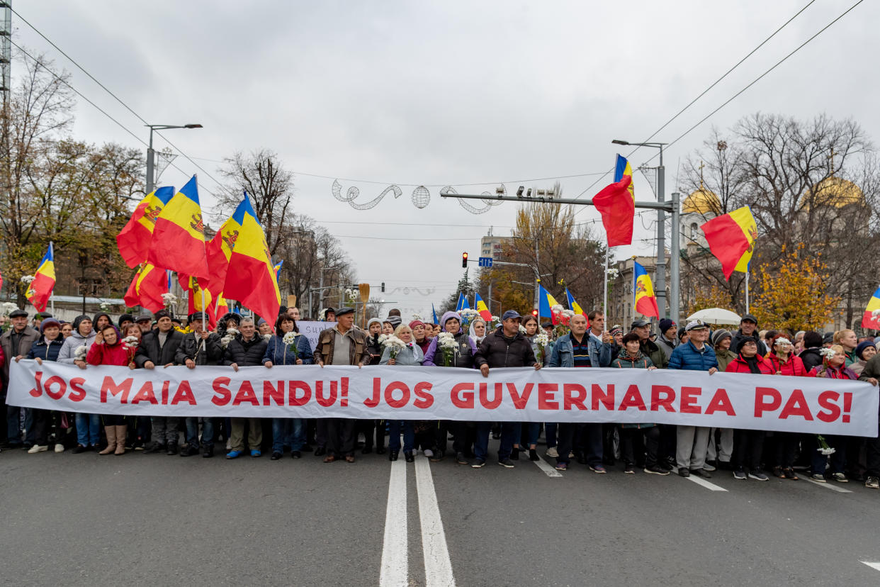 Several thousand protesters, holding Moldovan flags and a banner saying: Jos Maia Sandu! Jos Guvernarea Pas!  