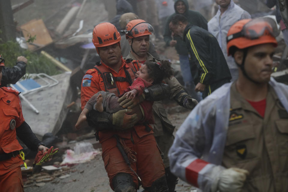 Rescue workers carry a 4-year-old girl from her collapsed house after heavy rains in Petropolis, Rio de Janeiro state, Brazil, Saturday, March 23, 2024. (AP Photo/Bruna Prado)