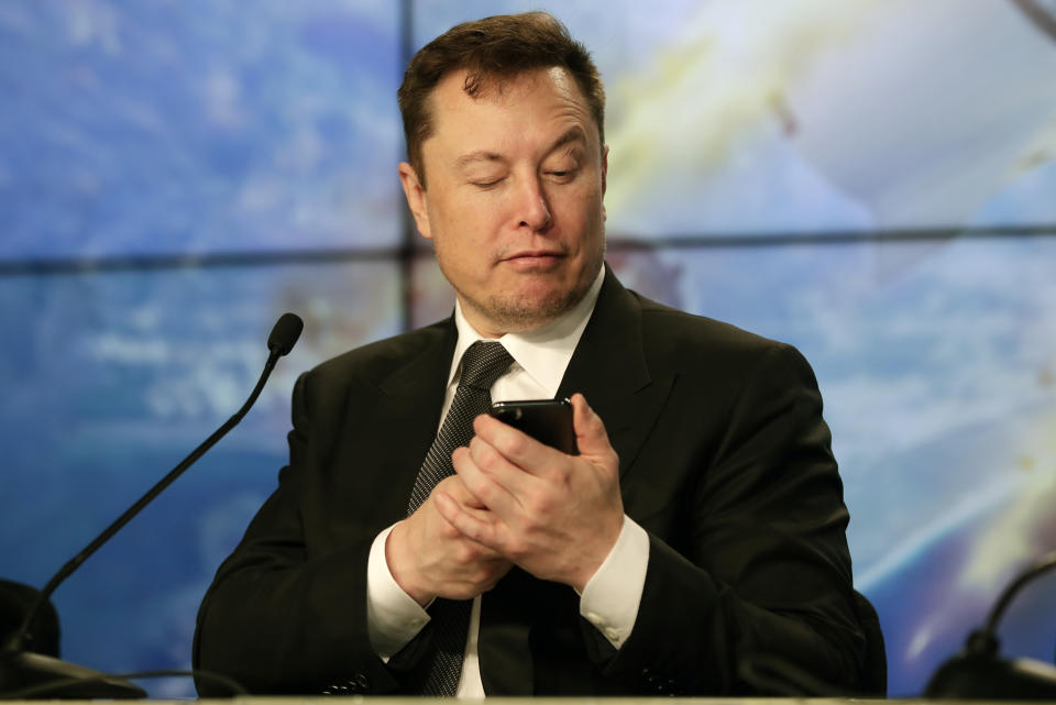 FILE - Elon Musk founder, CEO, and chief engineer/designer of SpaceX jokes with reporters as he pretends to search for an answer to a question on a cell phone during a news conference after a Falcon 9 SpaceX rocket test flight to demonstrate the capsule's emergency escape system at the Kennedy Space Center in Cape Canaveral, Fla., Sunday, Jan. 19, 2020.  Many people are puzzled on what a Elon Musk takeover of Twitter would mean for the company and even whether he’ll go through with the deal.  If the 50-year-old Musk’s gambit has made anything clear it’s that he thrives on contradiction. (AP Photo/John Raoux, File)