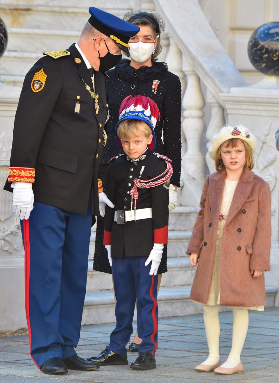 Prince Albert II of Monaco, Princess Gabriella and Prince Jacques stand with a message for Princess Charlene at the balcony of Monaco Palace