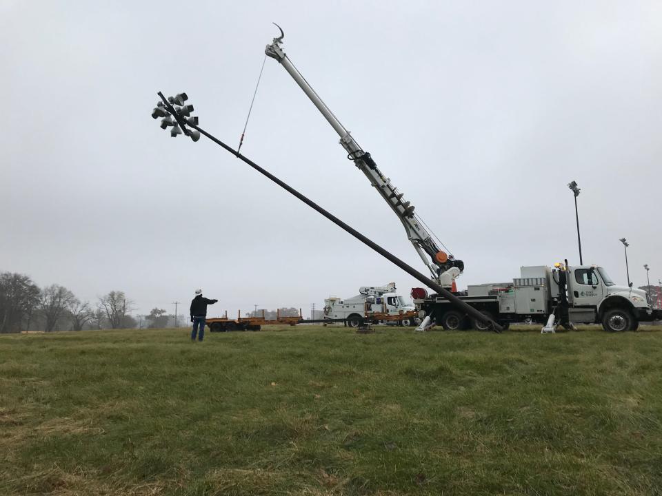 Volunteers from Duke Energy take down the first of 10 light poles from Purdue University's former Intramural Black Fields on Monday, Nov. 18, 2019, at the southwest corner of State Street and Airport Road. The lights and 65-foot poles were donated by Purdue Research Foundation and delivered by Duke Energy to the Abby and Libby Memorial Park near Delphi.