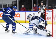 Winnipeg Jets goaltender Connor Hellebuyck (37) makes a save against Toronto Maple Leafs left wing Zach Hyman (11) during third period NHL hockey action in Toronto on Monday, Jan. 18, 2021. (Nathan Denette/The Canadian Press via AP)