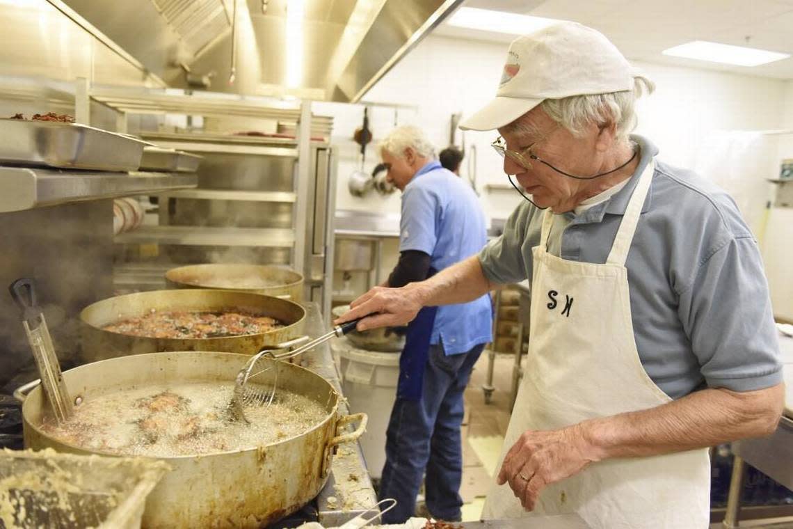 Volunteers Steve Weiss, right, and Larry Rocamora, center, fry latkes for the 2016 Hanukkah Festival at the Levin JCC in Durham. Latkes were available for purchase along with babka, gelt and doughnuts.