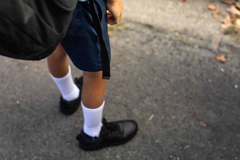 Young boy stands in his school uniform