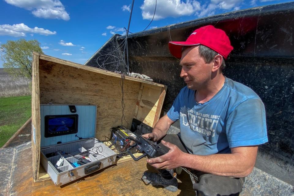 A worker uses a remote control to operate the demining machine (REUTERS)