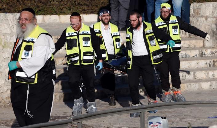 Ultra-Orthodox Jewish ZAKA volunteers carry the body of a Palestinian assailant following an attack at Damascus Gate, a main entrance to Jerusalem's Old City, on February 3, 2016 (AFP Photo/Ahmad Gharabli)