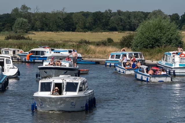 Pleasure boats make their way along the River Ant at Ludham Bridge on the Norfolk Broads