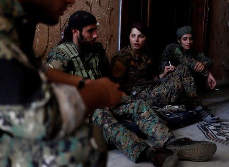 Kurdish fighters from the People's Protection Units (YPG) sit in a house in Raqqa, Syria June 28, 2017. REUTERS/Goran Tomasevic