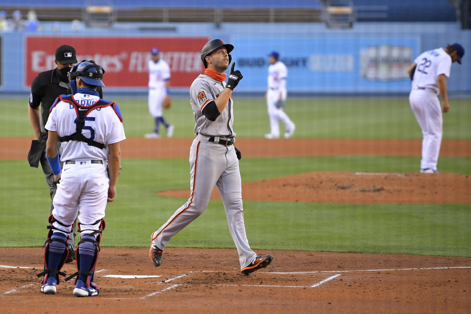 San Francisco Giants' Austin Slater, front right, gestures as he scores after hitting a solo home run, while Los Angeles Dodgers catcher Austin Barnes, left, and starting pitcher Clayton Kershaw, back right, stand at their positions during the third inning of a baseball game Saturday, Aug. 8, 2020, in Los Angeles. (AP Photo/Mark J. Terrill)