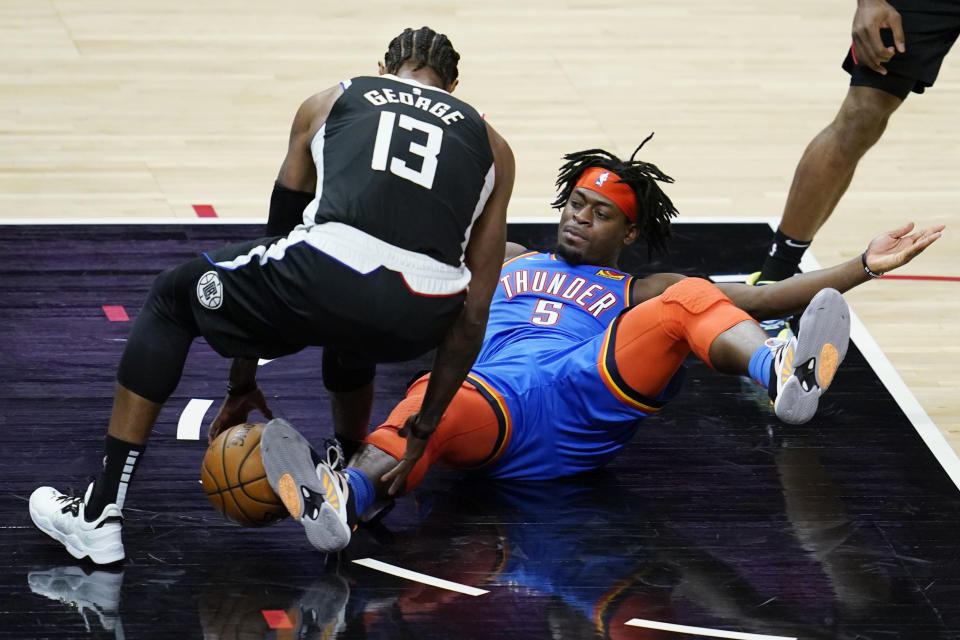 Los Angeles Clippers guard Paul George (13) picks up the ball next to Oklahoma City Thunder forward Luguentz Dort (5) during the third quarter of an NBA basketball game Friday, Jan. 22, 2021, in Los Angeles. (AP Photo/Ashley Landis)