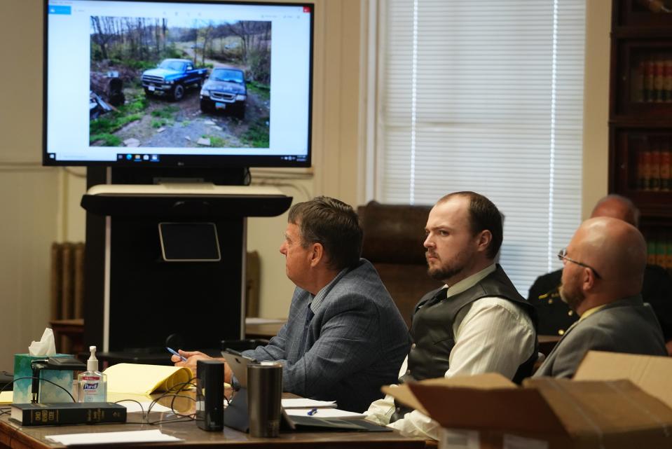 As the prosecution projects photos on three large digital screens in the Pike County Common Pleas Court on Sept. 15, 2022, defendant George Wagner IV, 30, sits between attorneys John P. Parker, left, and Richard M. Nash Jr. The photo on the screen pictures trucks parked at the home of victim Kenneth Rhoden at the time of his death.