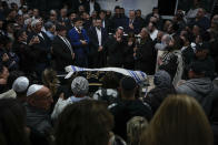 Mourners gather around the bodies of Israeli couple Eli Mizrahi and his wife, Natalie, victims of a shooting attack Friday in east Jerusalem, during their funeral at the cemetery in Beit Shemesh, Israel, early Sunday, Jan. 29, 2023. On Friday, a Palestinian gunman opened fire outside an east Jerusalem synagogue, killing the couple and another five people, including a 70-year-old woman, and wounding three others before he was shot and killed by police, officials say. It was the deadliest attack on Israelis since 2008 and raised the likelihood of more bloodshed. (AP Photo/Ariel Schalit)