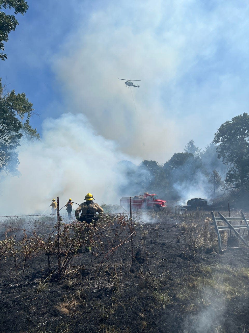 Firefighters work to extinguish the Sodaville Cutoff Fire in a partially harvested field south of Lebanon that threatened numerous homes Tuesday.