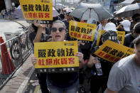 Protesters hold up words that read: "Strict enforcing of law against smugglers of grey goods" in Hong Kong Saturday, July 13, 2019. Several thousand people are marching in Hong Kong against traders from mainland China in what is fast becoming a summer of unrest in the semi-autonomous Chinese territory. (AP Photo/Kin Cheung)