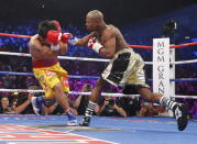 Manny Pacquiao of the Philippines covers his face as he is punched by Floyd Mayweather, Jr. of the U.S. in the first round during their welterweight WBO, WBC and WBA (Super) title fight in Las Vegas, Nevada, May 2, 2015. REUTERS/Steve Marcus