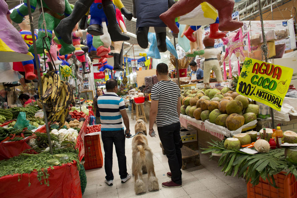 <p>Men shop along with their dog inside Mercado Medellin in Mexico City, May 20, 2016. Mexico is lowering its economic growth forecast for 2016, citing what it calls “adverse” international conditions including sluggish industrial production in the United States. (Rebecca Blackwell/AP) </p>