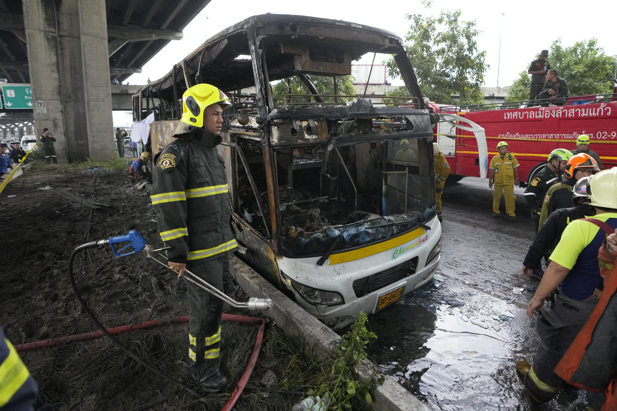 Rescuers work at the site of a bus that caught fire, carrying young students with their teachers, in suburban Bangkok, Tuesday, Oct. 1, 2024. (AP Photo/Sakchai Lalit)