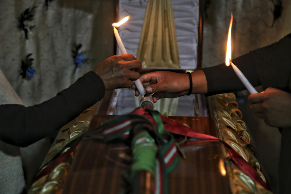 ARCHIVO - Deudos encienden velas sobre el ataúd con los restos del líder indígena Wilson Bomba, que fue asesinado por un hombre armado en un área en la que los ataques a civiles son comunes en medio de enfrentamientos cada vez más intensos entre grupos armados que luchan por el control de los cultivos de coca y las rutas de narcotráfico en Caldono, Colombia, el 18 de marzo de 2023. Un propuesta del presidente colombiano Gustavo Petro presentada al Congreso el miércoles 15 de marzo de 2023 pretende llevar ante la justicia a grupos criminales relacionados con el narcotráfico en un intento de desescalar los niveles de violencia en el país sudamericano. (AP Foto/Andrés Quintero, Archivo)