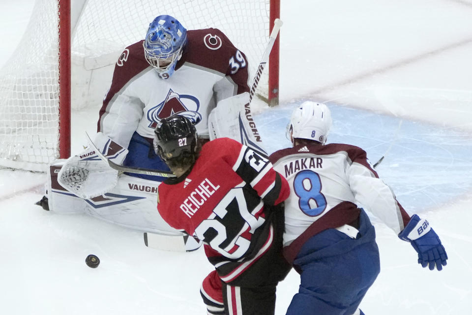 Colorado Avalanche goaltender Pavel Francouz makes a save on a shot by Chicago Blackhawks' Lukas Reichel (27) as Cale Makar also defends during the first period of an NHL hockey game Thursday, Jan. 12, 2023, in Chicago. (AP Photo/Charles Rex Arbogast)