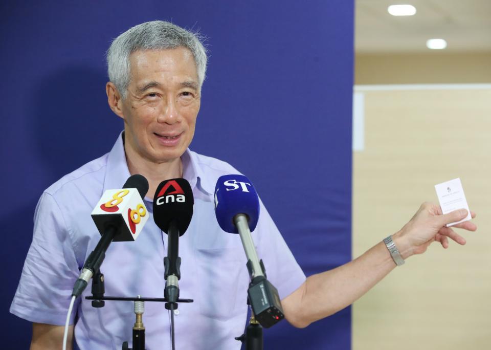 Prime Minister Lee Hsien Loong showing members of the media his vaccination card on 8 January 2020. (PHOTO: MCI)