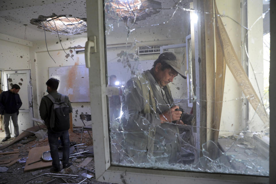 Journalists photograph inside Kabul University after a deadly attack in Kabul, Afghanistan, Tuesday, Nov. 3, 2020. The brazen attack by gunmen who stormed the university has left many dead and wounded in the Afghan capital. The assault sparked an hours-long gun battle. (AP Photo/Rahmat Gul)