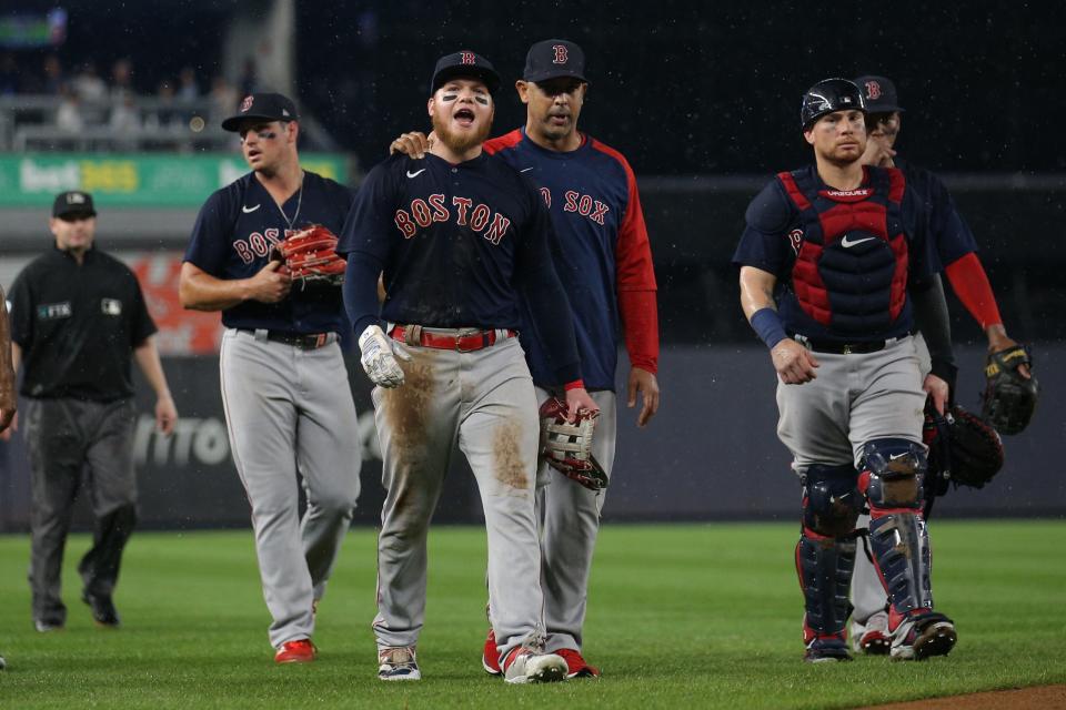 Jul 17, 2021; Bronx, New York, USA; Boston Red Sox left fielder Alex Verdugo (99) is walked off the field by manager Alex Cora (13) after a fan threw an object at him during the sixth inning against the New York Yankees at Yankee Stadium.