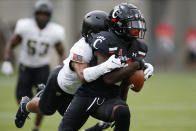 Army defensive back Javhari Bourdeau, left, tackles Cincinnati wide receiver Jayshon Jackson after a catch during the first half of an NCAA college football game Saturday, Sept. 26, 2020, in Cincinnati, Ohio. (AP Photo/Jay LaPrete)