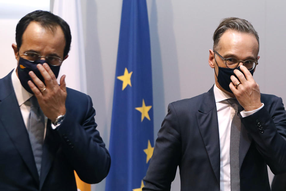 German Foreign Minister Heiko Maas, right, and his Cyprus' counterpart Nicos Christodoulides adjust their masks after their meeting and a press conference at the foreign ministry house in divided Nicosia, Cyprus, Tuesday, Oct. 13, 2020. Maas is in Cyprus for a one-day visit. (AP Photo/Petros Karadjias)