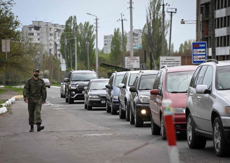 Un militar de Transnistria pasa junto a una fila de autos que hacen cola para salir de la autoproclamada 