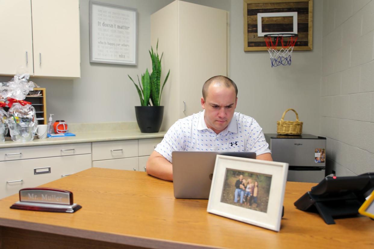 Mount Union Master of Education alumnus and Alliance Elementary School Principal Cory Muller works while in his office.