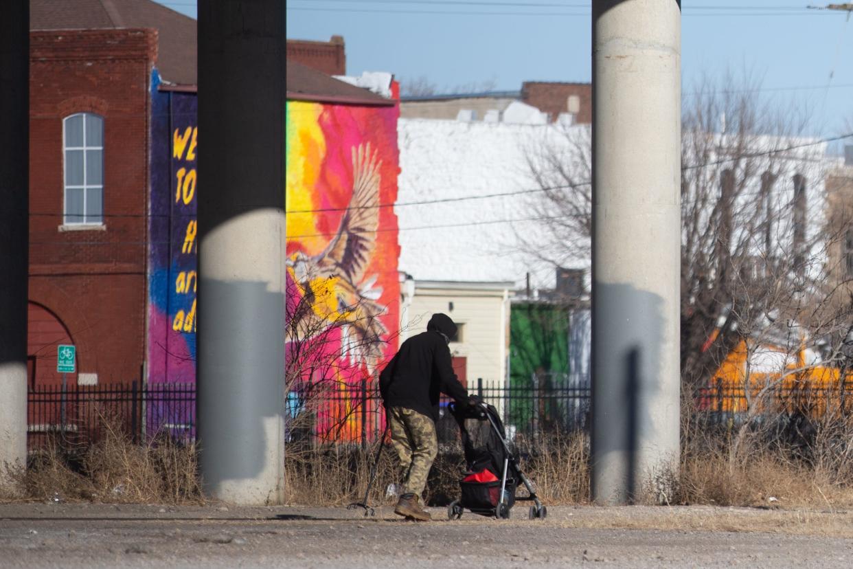 A man who is homeless pushes a stroller under the N. Kansas Avenue bridge Wednesday morning. Volunteers and employees with Valeo Behavioral Health were taking a count of the homeless population as part of a federal mandate to help allocate funding.