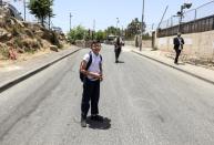 Ahmad, a member of the Abu Diab family, Palestinian residents of Sheikh Jarrah, stands in front of a Jewish man, as he makes his way home from school in his neighbourhood in East Jerusalem